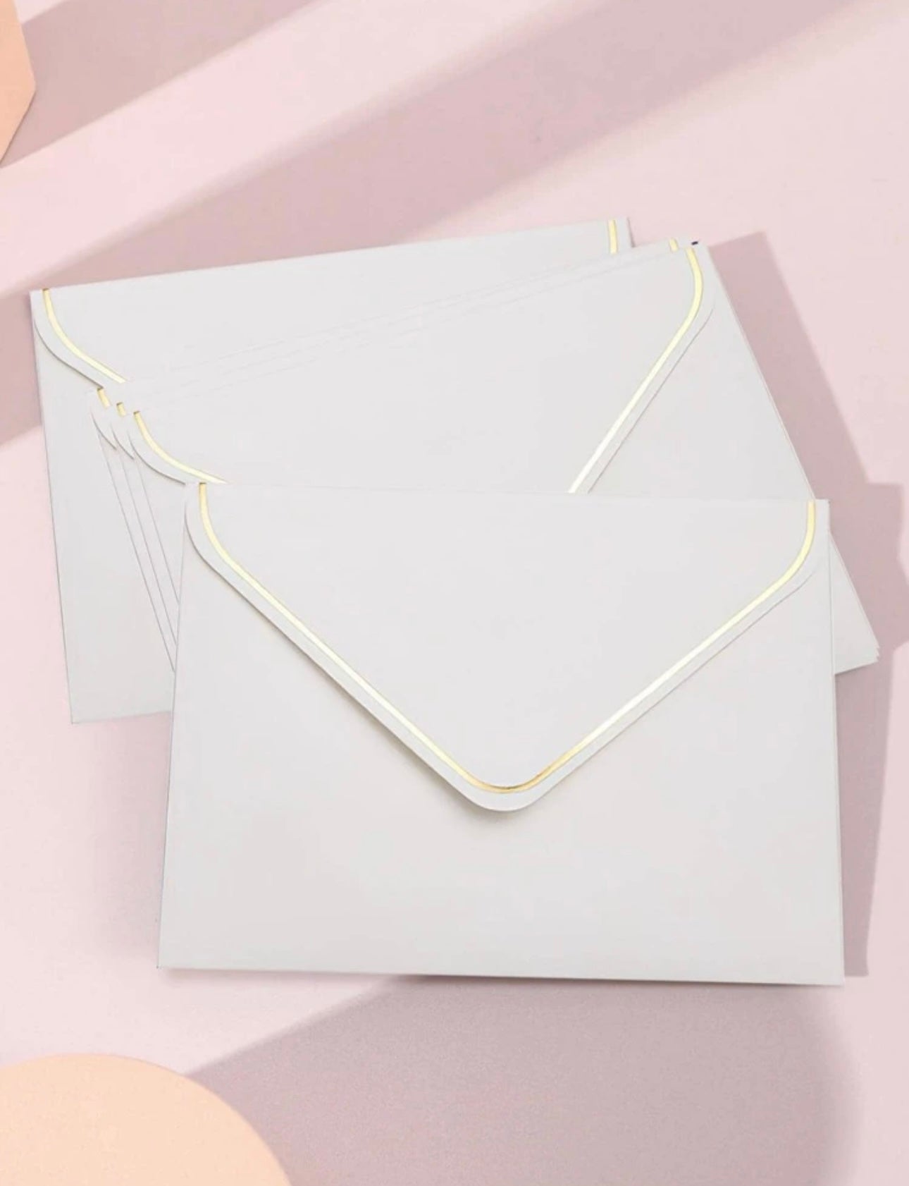 White envelopes with gold foil edging